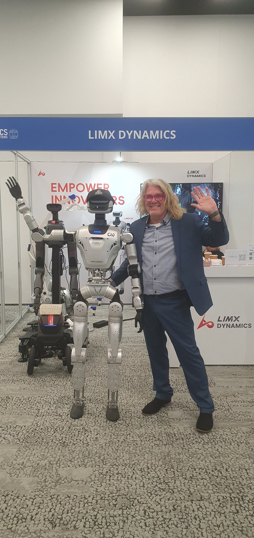 Cave from AussyBot beside LimX Oli, the full-size humanoid, at the LimX Dynamics booth at RSS 2026 in Sydney